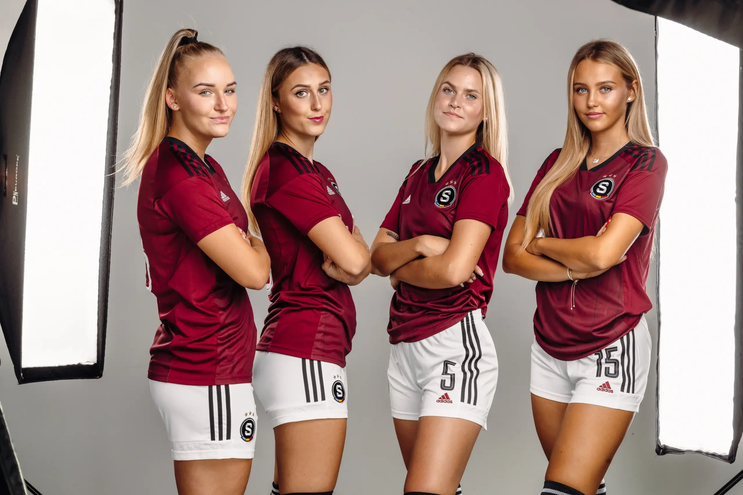 Four Czech players in dark red kits, arms crossed, facing the camera