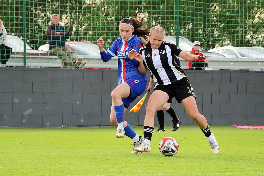 Two second-league players dueling for the ball beside the corner flag